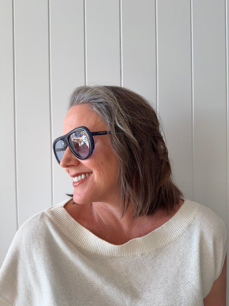 Woman wearing Mignight Monarchy navy blue sunglasses acetate frame UV400 light blue lenses